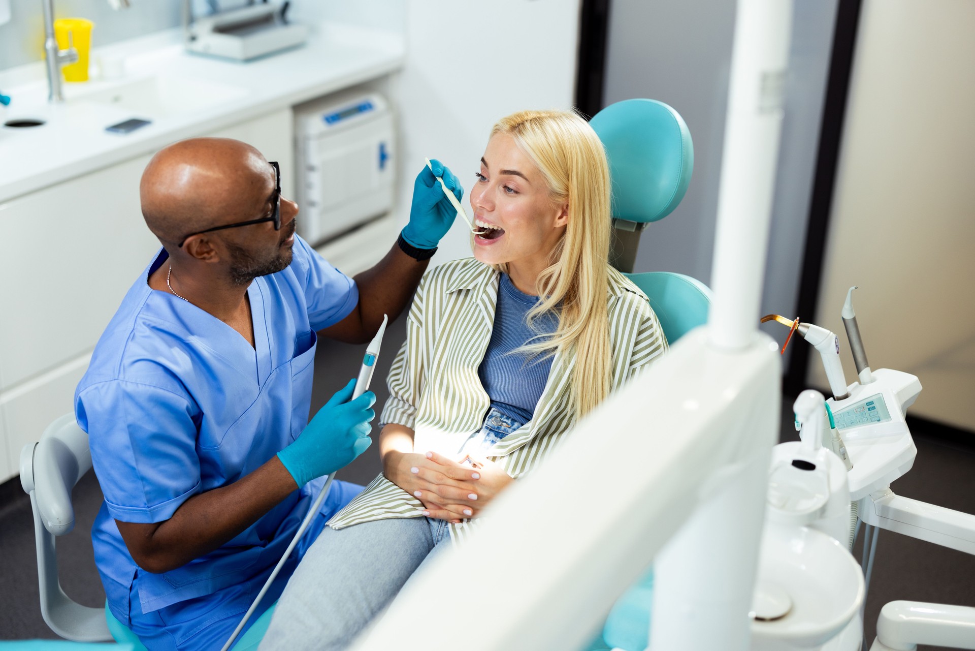 Dentist examining teeth of woman patient during dental checkup in clinic